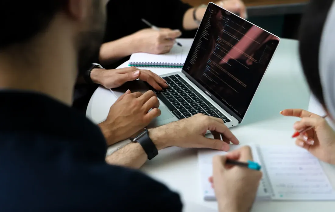 Consultants working on laptops in a meeting